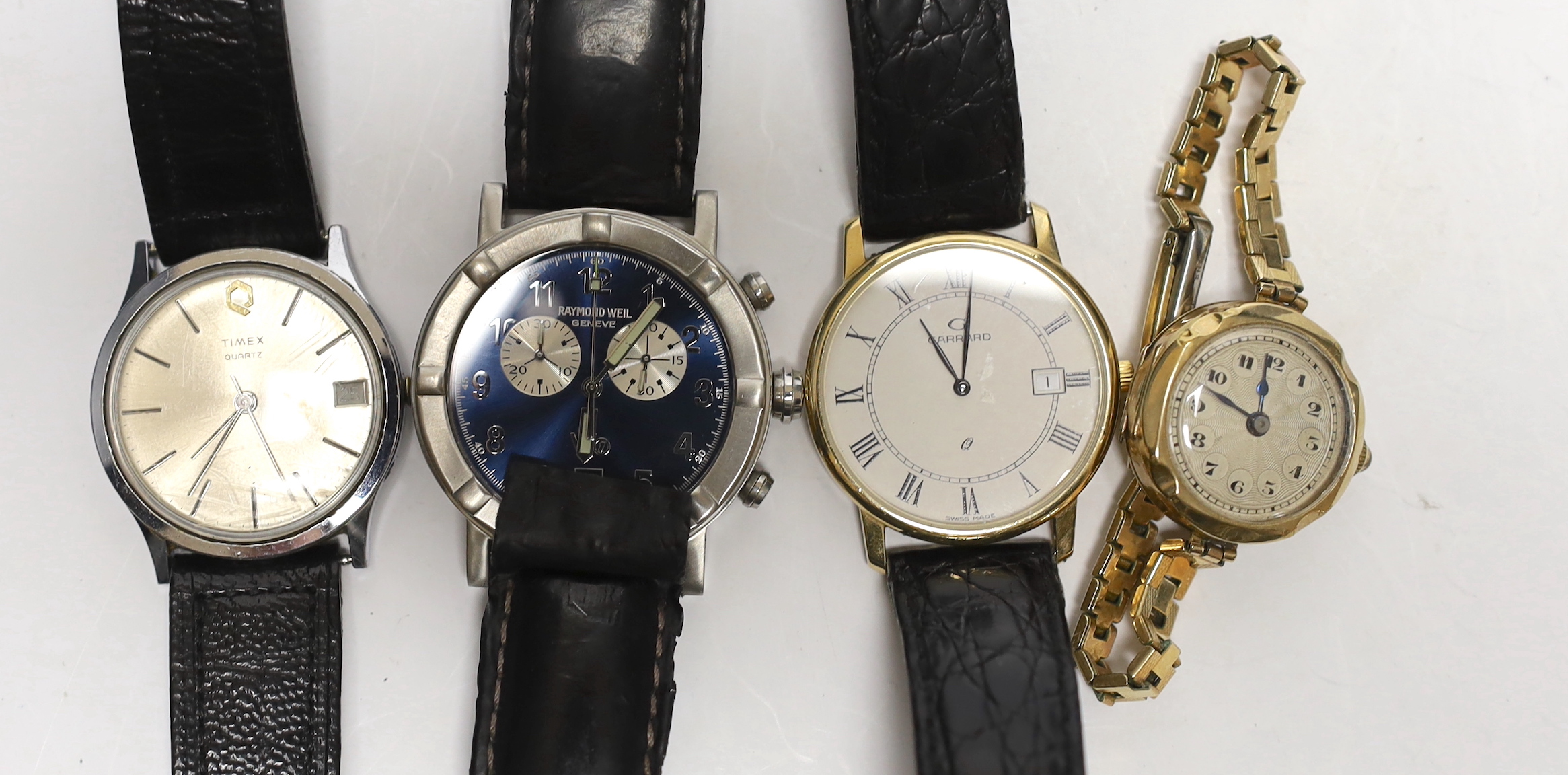 Three assorted gentleman's wrist watches including Raymond Weil, Timex and a 9ct gold quartz wrist watch, retailed by Garrard, together with a lady 9ct gold manual wind wrist watch, on steel and gold plated bracelet.